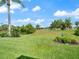 Spacious backyard with well-maintained lawn, landscaping, and blue sky at 85 Long Meadow Ct, Rotonda West, FL 33947