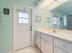 Bright bathroom featuring a door to the exterior and a vanity with ample storage at 85 Long Meadow Ct, Rotonda West, FL 33947