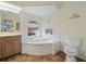 Well-lit bathroom with a soaking tub, neutral tile, storage, and a serene atmosphere at 85 Long Meadow Ct, Rotonda West, FL 33947