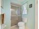 Bathroom featuring a glass shower, toilet, and a window with patterned curtains at 85 Long Meadow Ct, Rotonda West, FL 33947