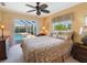 Bedroom with a ceiling fan and a sliding glass door providing a view of the pool at 85 Long Meadow Ct, Rotonda West, FL 33947