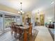 Well-lit dining room featuring a bay window, hardwood flooring, and a chandelier above the table with seating for six at 85 Long Meadow Ct, Rotonda West, FL 33947