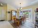 Bright dining room with a display cabinet, bay windows, a chandelier, and hardwood flooring at 85 Long Meadow Ct, Rotonda West, FL 33947
