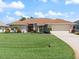 Beautiful single-story home featuring a well-manicured lawn, a two-car garage, and a lovely front yard with mature landscaping at 85 Long Meadow Ct, Rotonda West, FL 33947