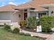 Close-up of a charming home's entrance with lush landscaping and beautiful shrubbery at 85 Long Meadow Ct, Rotonda West, FL 33947