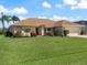Well-maintained single-story home with a two car garage, lush green lawn and beautiful landscaping at 85 Long Meadow Ct, Rotonda West, FL 33947