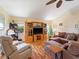 Cozy living room with hardwood floors, ceiling fan, comfortable sofa, and a built-in entertainment center at 85 Long Meadow Ct, Rotonda West, FL 33947