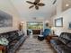 Spacious living room boasting comfortable seating, a ceiling fan, and views of the pool through the sliding glass doors at 85 Long Meadow Ct, Rotonda West, FL 33947