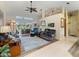 Open concept living room with high ceilings, comfortable sofas, and a sliding glass door to the screened in patio at 85 Long Meadow Ct, Rotonda West, FL 33947