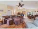 Spacious living room showcasing hardwood floors, ceiling fan, comfortable sofa, and an open floor plan at 85 Long Meadow Ct, Rotonda West, FL 33947
