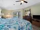Relaxing main bedroom with a ceiling fan, hardwood floors, king bed, and sliding glass doors to the pool area at 85 Long Meadow Ct, Rotonda West, FL 33947
