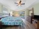 Tranquil main bedroom with a ceiling fan, hardwood floors, king bed, and sliding glass door to the pool area at 85 Long Meadow Ct, Rotonda West, FL 33947