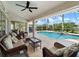 Relaxing screened patio featuring wicker furniture and a view of the pool at 85 Long Meadow Ct, Rotonda West, FL 33947