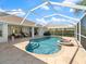 Inviting screened pool and spa with stone tile deck under a blue sky at 85 Long Meadow Ct, Rotonda West, FL 33947