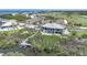 Aerial view of an estate home with a dock on a canal and a golf course in the background at 10161 Eagle Preserve Dr, Englewood, FL 34224