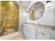 Elegant powder room featuring custom vanity, granite countertop, arched mural, and decorative lighting at 10161 Eagle Preserve Dr, Englewood, FL 34224
