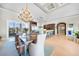 Well lit dining room with tray ceilings, decorative chandelier and direct access to the outdoor balcony at 10161 Eagle Preserve Dr, Englewood, FL 34224