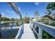 Boat dock with a lift on a canal with a private boat house and lush surroundings at 10161 Eagle Preserve Dr, Englewood, FL 34224