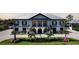 Stunning two-story home with a metal roof, manicured landscaping, and a circular driveway at 10161 Eagle Preserve Dr, Englewood, FL 34224
