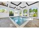 Bright indoor pool area with multiple windows offering beautiful views and brick flooring at 10161 Eagle Preserve Dr, Englewood, FL 34224