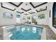 Stunning indoor pool area with high ceilings, ceiling fans, natural light, and comfortable seating at 10161 Eagle Preserve Dr, Englewood, FL 34224