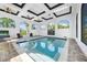 This bright indoor pool area has brick flooring, seating and multiple windows offering beautiful views at 10161 Eagle Preserve Dr, Englewood, FL 34224