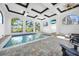 Bright indoor pool area featuring television, lounge chairs and multiple windows with tropical views at 10161 Eagle Preserve Dr, Englewood, FL 34224