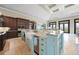 Bright kitchen island featuring an island sink, custom cabinetry, and access to great room at 10161 Eagle Preserve Dr, Englewood, FL 34224