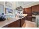 Gourmet kitchen featuring marble countertops and custom dark wood cabinetry with stainless steel appliances at 10161 Eagle Preserve Dr, Englewood, FL 34224