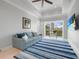 Comfortable sitting area featuring a blue sofa, ceiling fan, golf course view, and mounted TV at 10161 Eagle Preserve Dr, Englewood, FL 34224