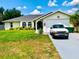 Charming home featuring a well-maintained lawn, attached garage, and lovely front yard landscaping at 1017 Guild St, Port Charlotte, FL 33952