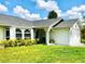 Well-maintained single-story home with a lush green lawn and a welcoming entrance at 1017 Guild St, Port Charlotte, FL 33952