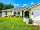 Charming home featuring a well-maintained lawn, attached garage, and lovely front yard landscaping at 1017 Guild St, Port Charlotte, FL 33952