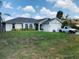 Charming home featuring a well-maintained lawn, attached garage, and lovely front yard landscaping at 1017 Guild St, Port Charlotte, FL 33952
