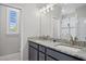 Bathroom with double sinks, stone counters, and a separate glass enclosed shower at 111 Britt Rd, Rotonda West, FL 33947