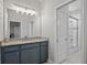 Bathroom featuring a vanity with granite counters, a framed mirror, and a glass-enclosed shower/tub at 111 Britt Rd, Rotonda West, FL 33947