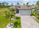 Beautiful home featuring a paved driveway, lush landscaping, and a two-car garage at 111 Britt Rd, Rotonda West, FL 33947