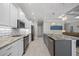 Bright kitchen features white cabinets, stainless appliances, stone counters and island with sink and dishwasher at 111 Britt Rd, Rotonda West, FL 33947