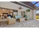 Covered patio with comfortable wicker furniture surrounding a stone fire pit, with the house visible behind at 111 Britt Rd, Rotonda West, FL 33947