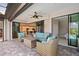 Covered patio with wicker furniture overlooking the open kitchen and view to a bedroom on the right at 111 Britt Rd, Rotonda West, FL 33947