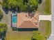 Overhead view of a beautiful home featuring a sparkling pool and well-maintained lawn at 118 Naomi Pl, Rotonda West, FL 33947