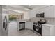 Modern kitchen featuring stainless steel appliances, white cabinets, and views of the pool area at 118 Naomi Pl, Rotonda West, FL 33947