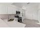 Well-lit kitchen with modern appliances, stylish backsplash, light countertop, and sleek gray flooring at 118 Naomi Pl, Rotonda West, FL 33947