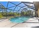 Enclosed swimming pool with waterfall feature and privacy screening at 118 Naomi Pl, Rotonda West, FL 33947