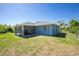 Backyard showing a screened in lanai and fenced yard providing a private outdoor space at 12185 Weimar Ave, Port Charlotte, FL 33981