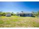 View of the backyard including a storage shed and screened-in patio area at 12185 Weimar Ave, Port Charlotte, FL 33981