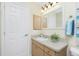 Clean bathroom with a vanity, storage cabinet, and white door, enhancing the space's brightness at 12185 Weimar Ave, Port Charlotte, FL 33981