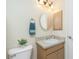 Bathroom with a vanity, round mirror, and overhead lighting, creating a cozy ambiance at 12185 Weimar Ave, Port Charlotte, FL 33981