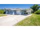Exterior view showcasing the home's attached garage, driveway, and convenient carport at 12185 Weimar Ave, Port Charlotte, FL 33981