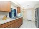 Well-lit kitchen showcasing wooden cabinets, stainless steel sink and exterior view window at 12185 Weimar Ave, Port Charlotte, FL 33981